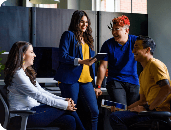 Employees in a meeting sitting around a computer